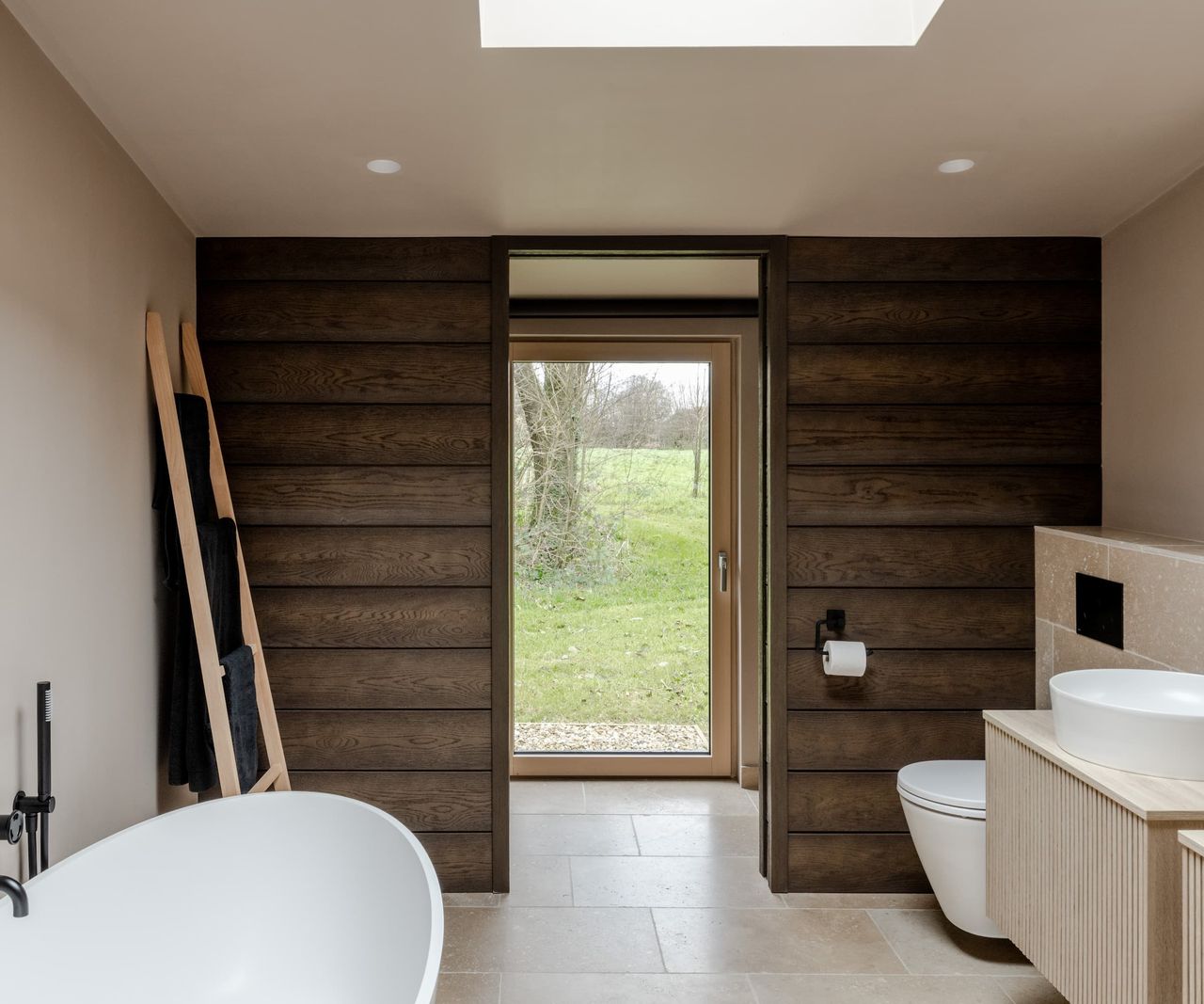 A bathroom with a standalone bath and rooflight