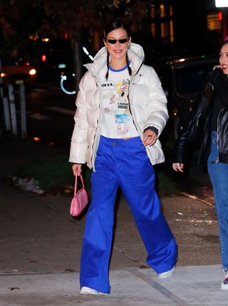 A photo of Bella Hadid wearing a cropped white Aritzia Super Puff with a glossy finish.