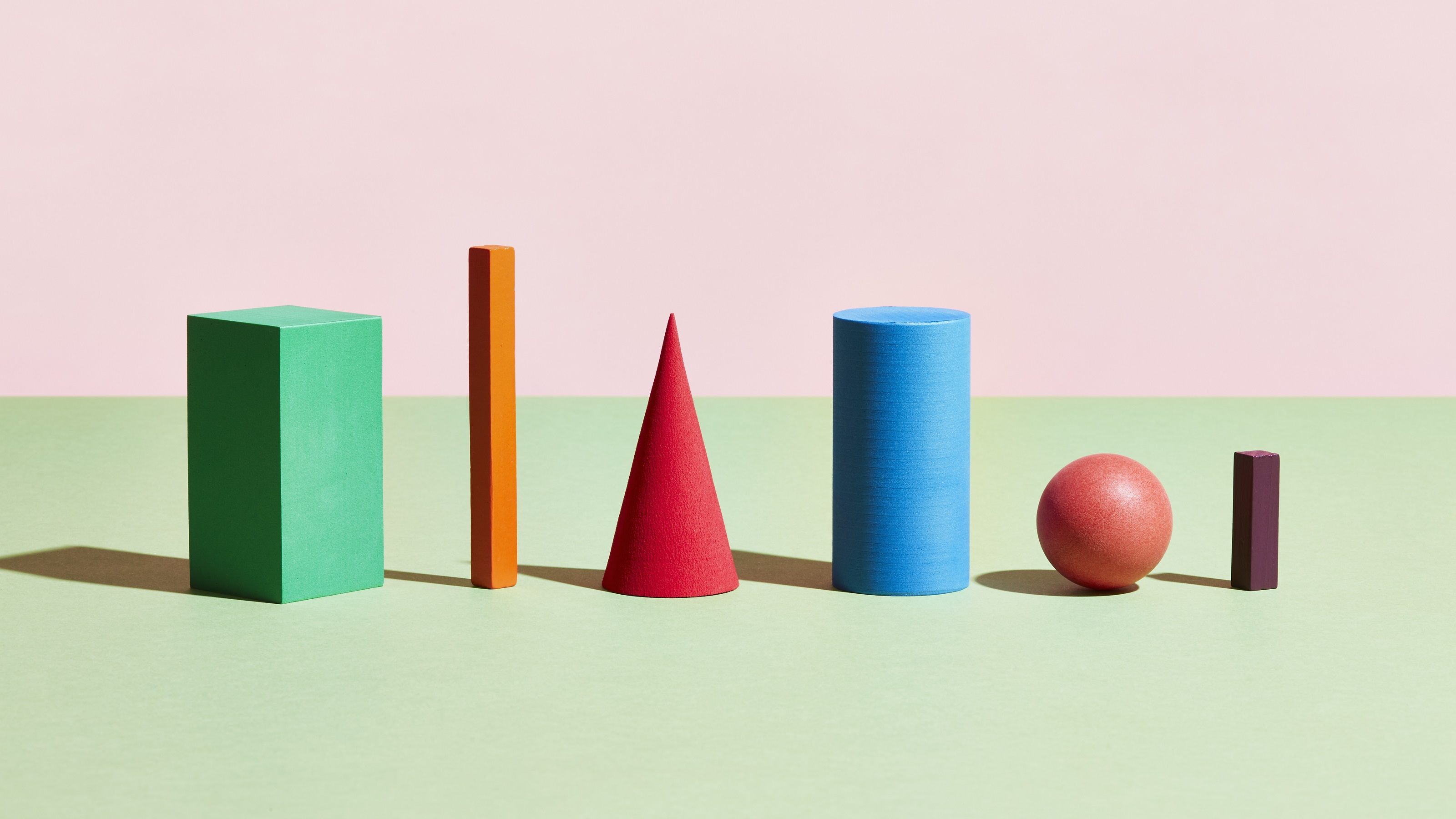 Different-colored and -shaped blocks against a pink and green background.