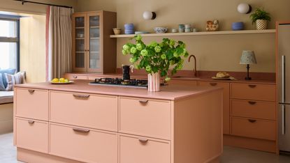 A contemporary kitchen in a soft contrast palette of pink, terracotta, wood, and stone colors and materials