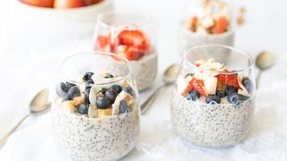 Banana And Coconut Overnight Oats topped with fresh fruit in glasses