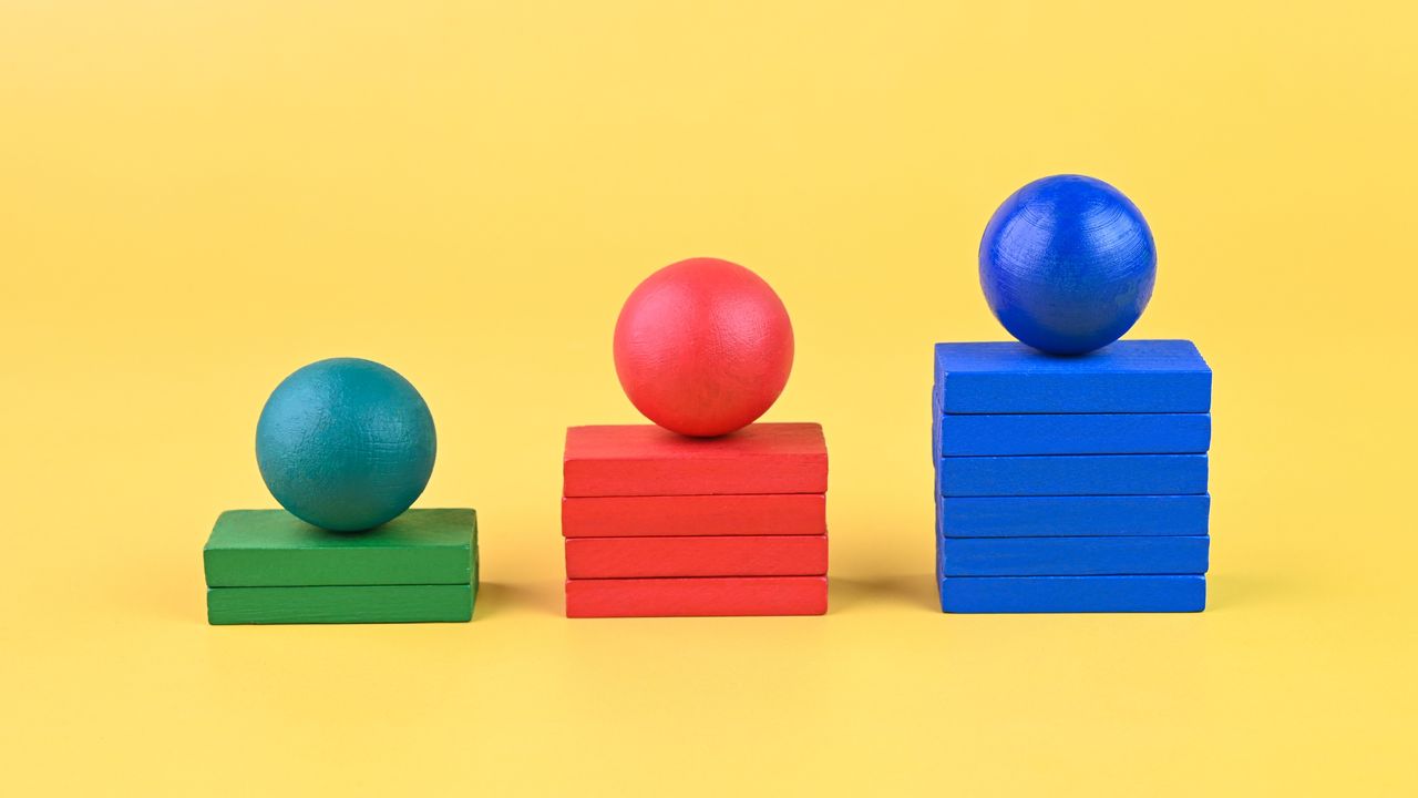 Three colorful stacks of blocks with a wooden ball on top of each.