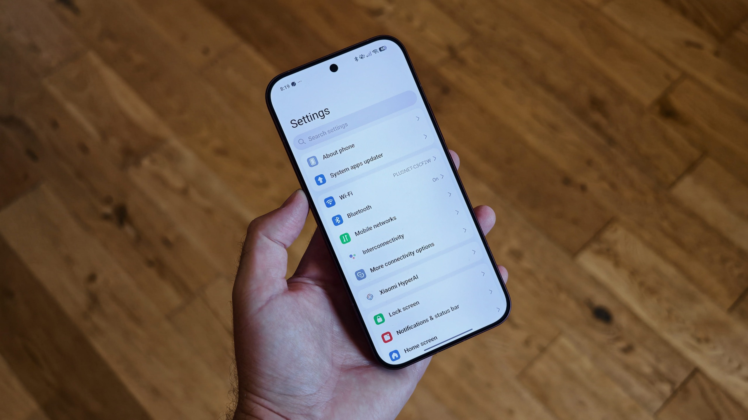 The Poco F9 Ultra being held in the hand and resting on a table