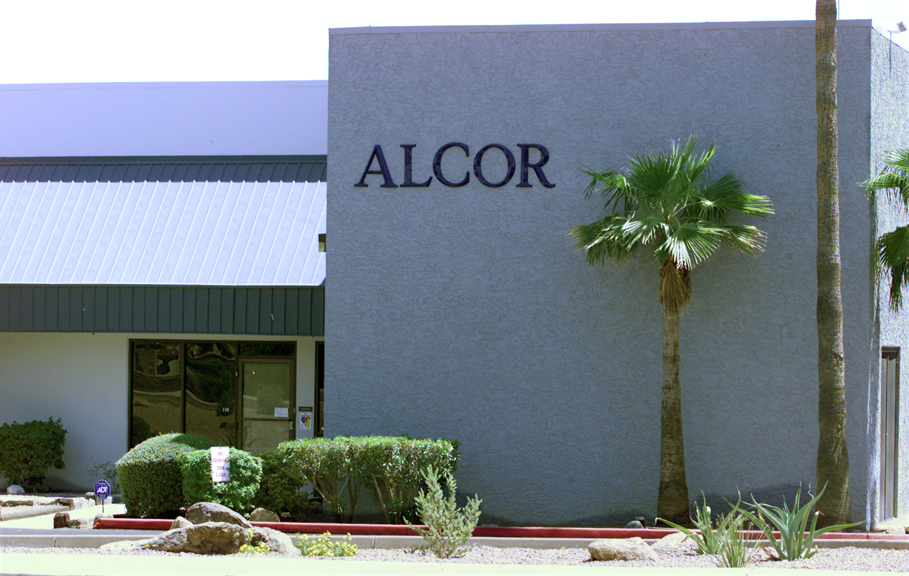 exterior of the Alcor Life Extension Foundation, a cryonics lab, with two palm trees outside