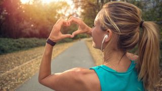 Woman runner holding hands up in a heart shape