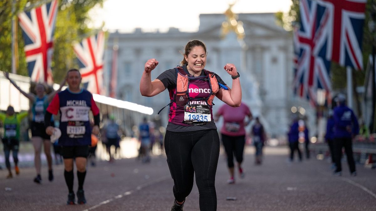 A runner celebrates as they cross the finish line on The Mall, The TCS London Marathon on Sunday 2nd October 2022