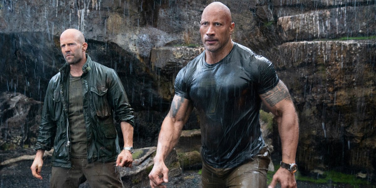 Jason Statham and Dwayne Johnson walk in the rain in Hobbs and Shaw.