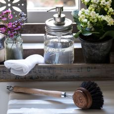 mason jar pump wih liquid soap and wooden dish brush