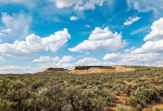 Earthship community in Taos showing colourful off grid homes nestled into the desert earth