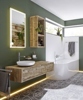 An example of LED bathroom lighting ideas showing LED lights along the floor in a green bathroom and around the mirror
