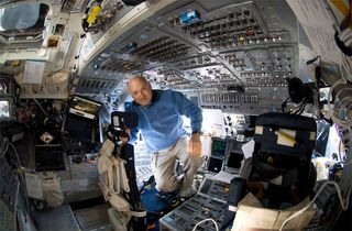 Astronaut Mark Kelly takes a moment for a photo near the commander's station on the forward flight deck of Space Shuttle Discovery during the STS-124 mission.