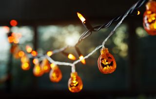 Halloween party ideas illustrated by Pumpkin electric light string against the window. Halloween theme