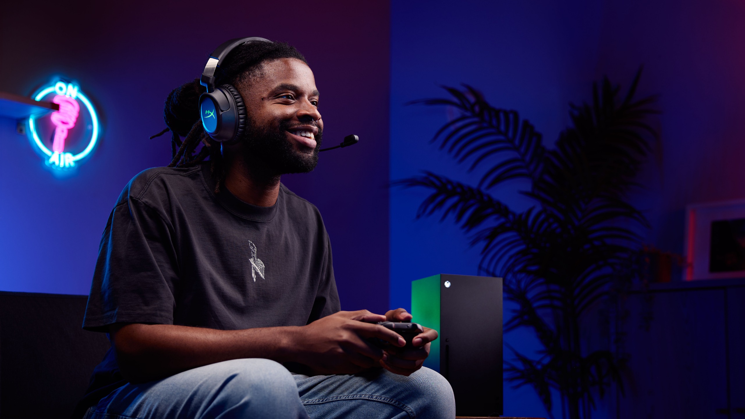 A man wears a HyperX wireless gaming headset while playing on an Xbox Series X console.