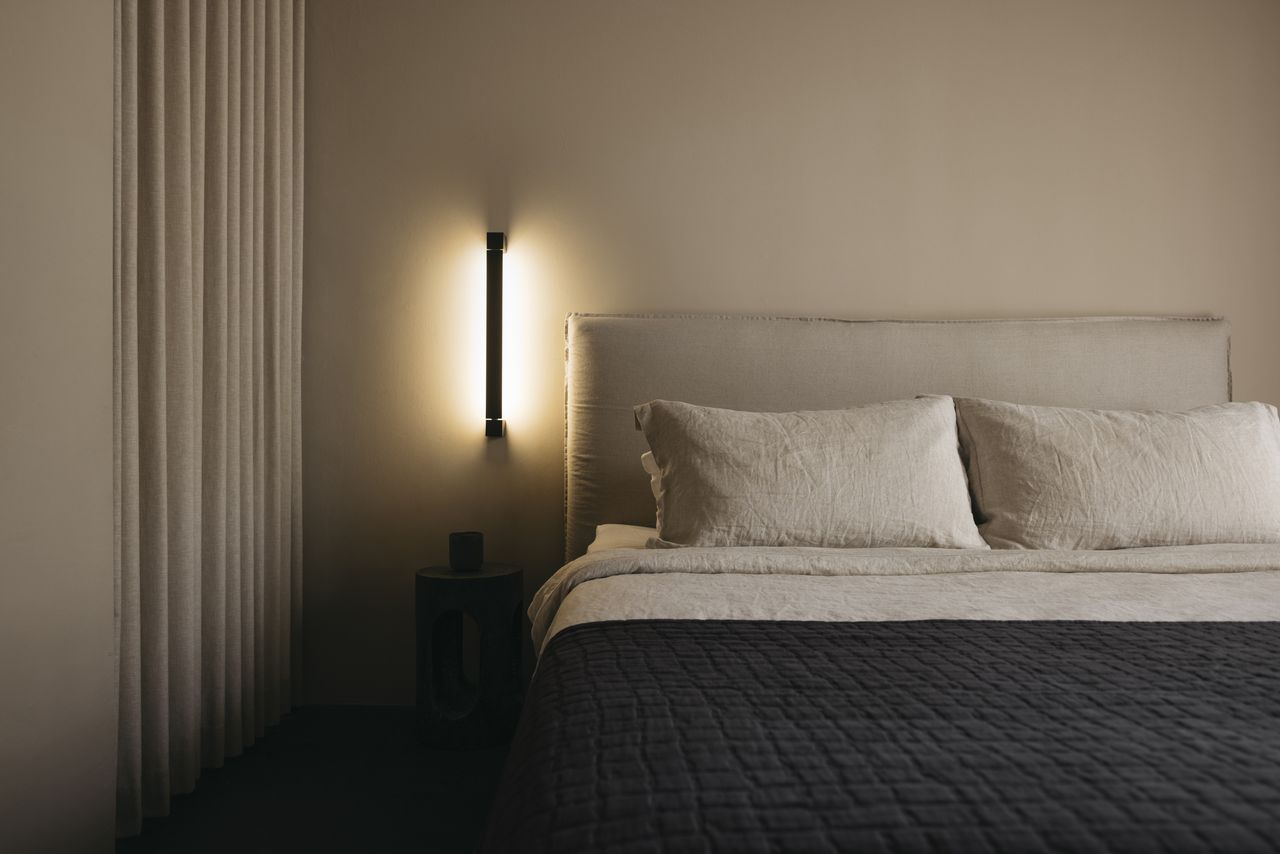 A bedroom with a recessed lighting and beige walls