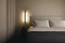 A bedroom with a recessed lighting and beige walls