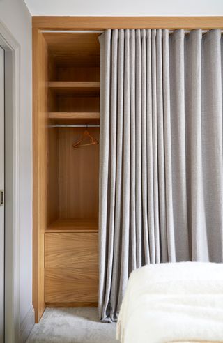 Wooden cupboard with grey curtain as a cupboard door.