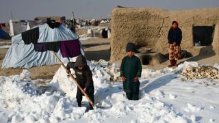 Boys in Afghanistan shovel snow after wave of freezing temperatures