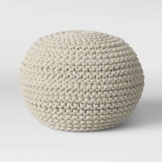 A cream colored chunky knit pouf as one of the best Target furniture pieces.