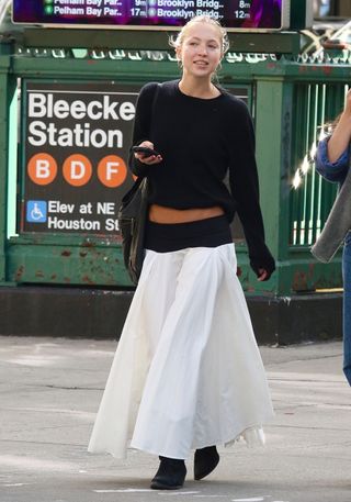 Lila Moss wearing a white skirt outfit.