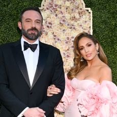 Ben Affleck wears a tuxedo and Jennifer Lopez wears a pink strapless gown with ruffle sleeves