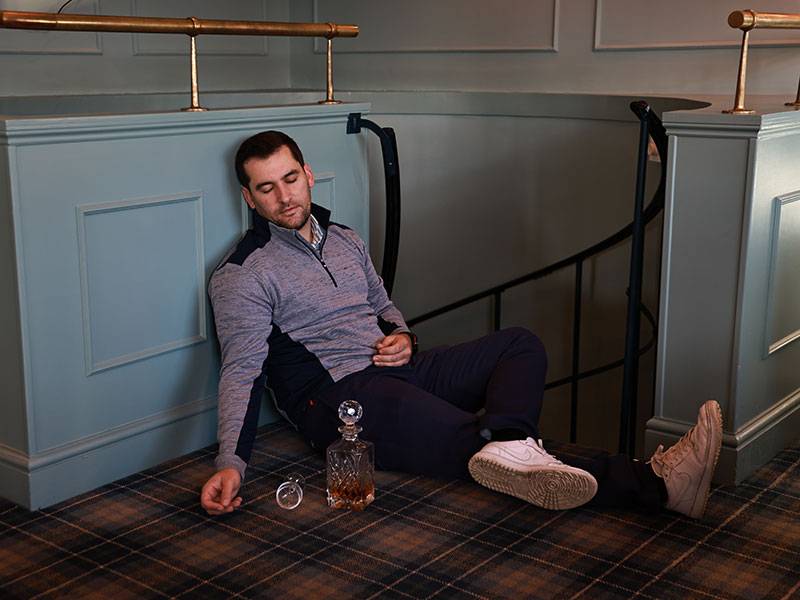 Sam De&#039;Ath drunk and asleep at a golf club with a bottle of whisky next to him