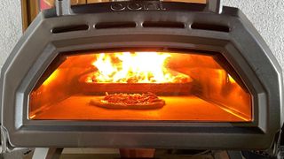 Beste pizzaovn: Ooni Karu 16 med en pizza ved flammene