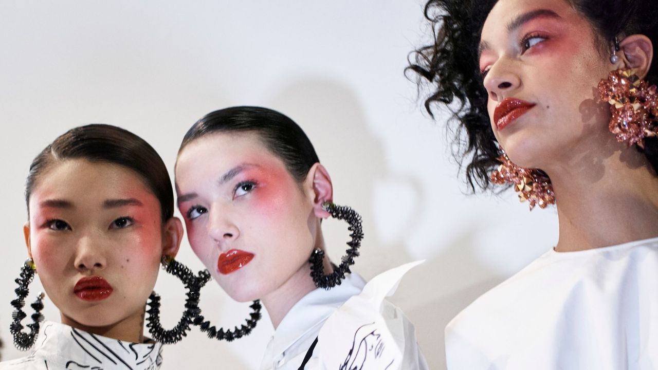 three models with red blusher make-up backstage at paris fashion week during the kenzo show - best red blusher