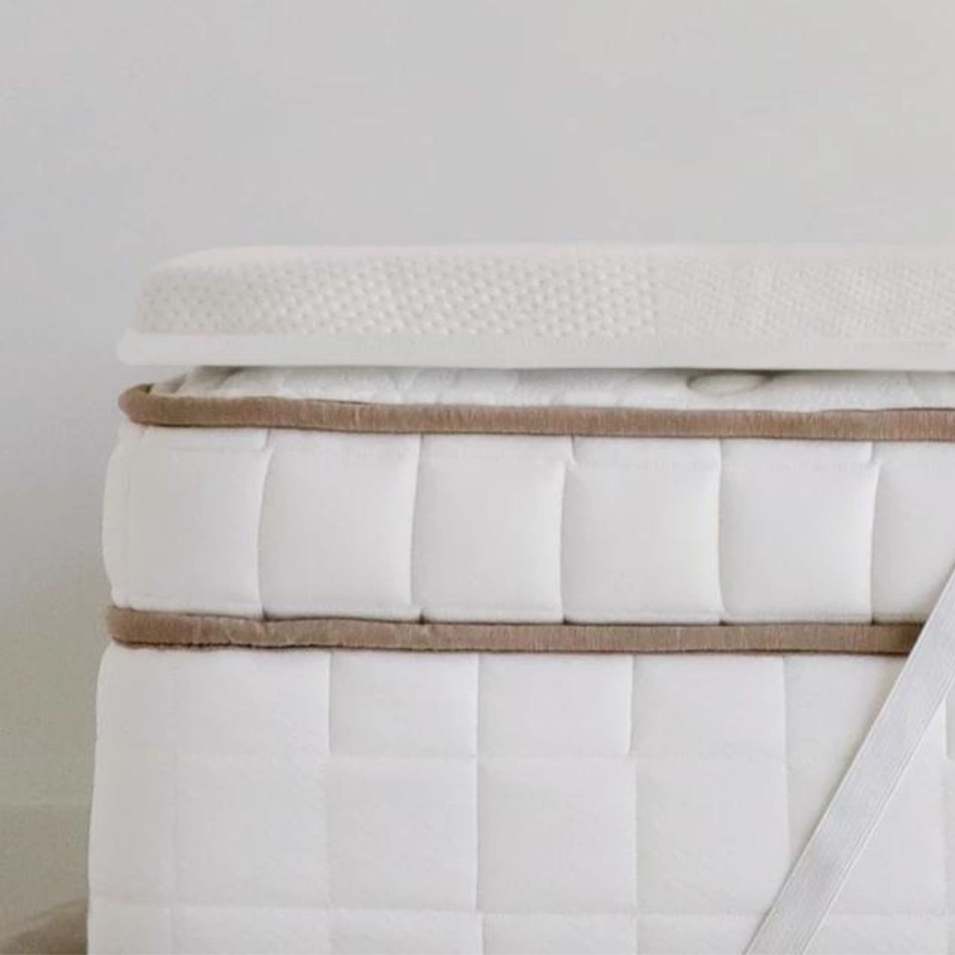 Bantalan kasur di tempat tidur di atas kasur bermerek