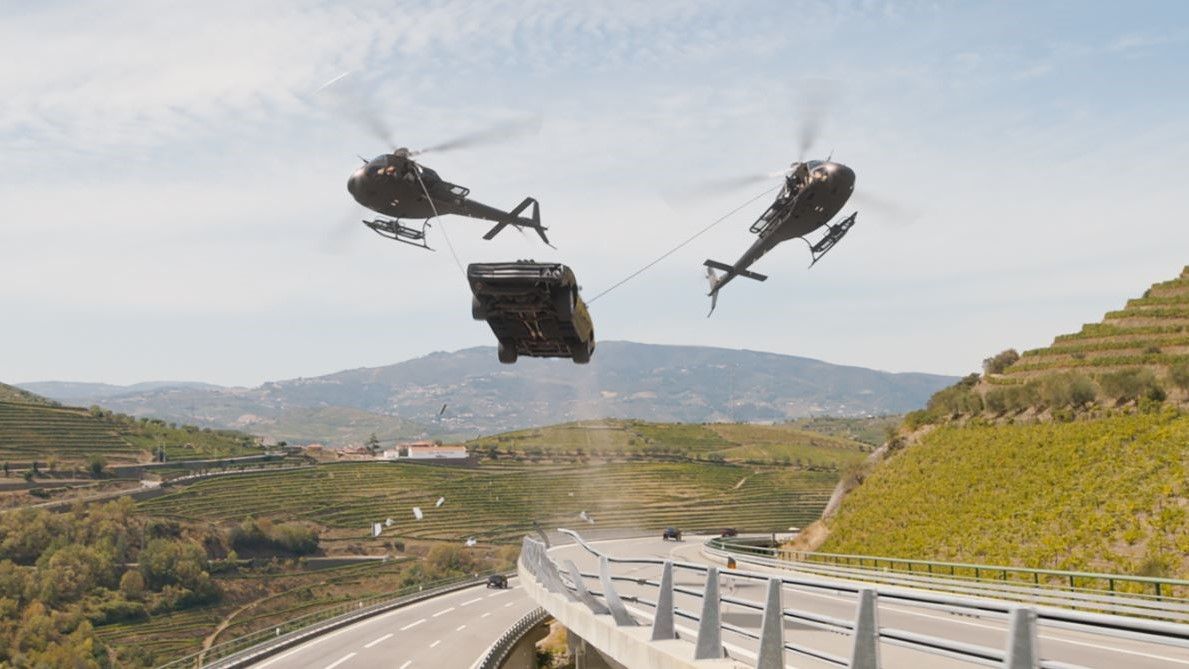 Helicopters lifting a car above a highway in Fast X