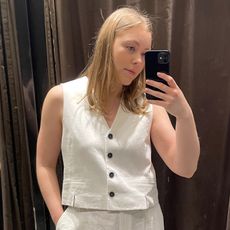 Woman in dressing room wears white waistcoat