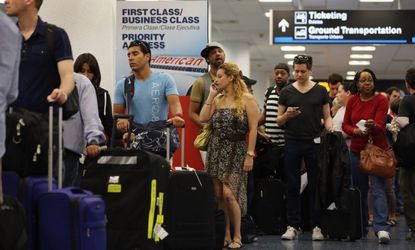 American Airlines passengers wait in line for a flight at Miami International Airport on April 16.