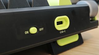 A black and green NuPhy Field75 keyboard on a wooden desk