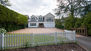 white picket fence in front of New England style house