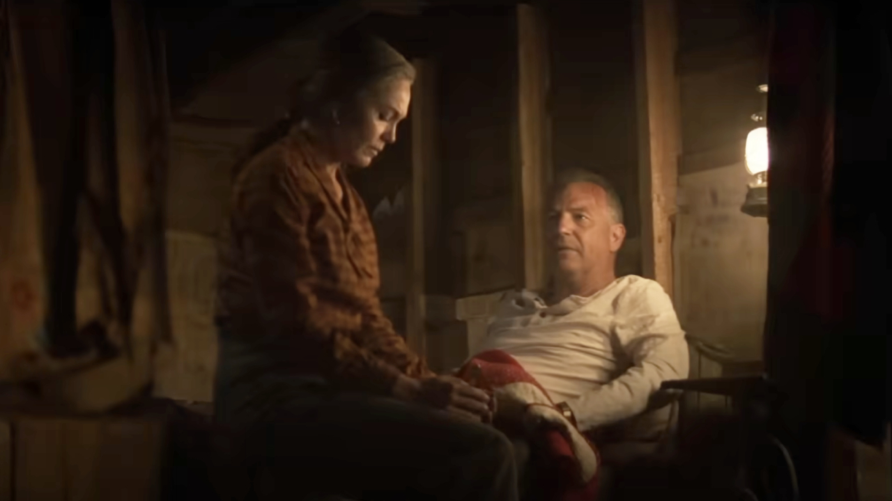 Diane Lane and Kevin Costner sitting by a lantern in Let Him Go