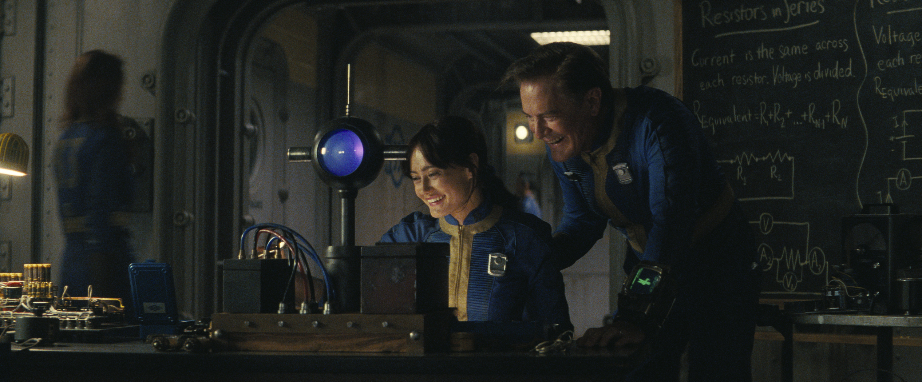 lucy (ella purnell) and hank maclean (kyle maclachlan) do a science experiment in a classroom, in 'fallout'
