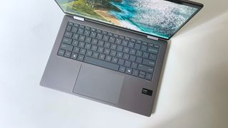 The keyboard deck of the HP Envy x360 2-in-1 seen from above on a white desk