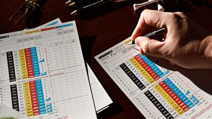 Golfer filling in a scorecard