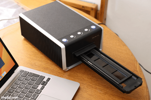 moving gif of the Plustek OpticFilm 135i film tray moving in and out of the scanner on a wooden surface