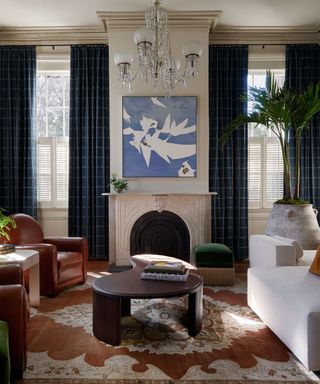 ralph lauren inspired living room with leather chairs and plaid curtains around a fireplace