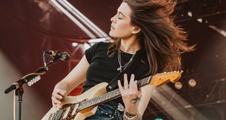 Rebecca Lovell plays a riff on her Fender Stratocaster as Larkin Poe perform an outdoor gig.