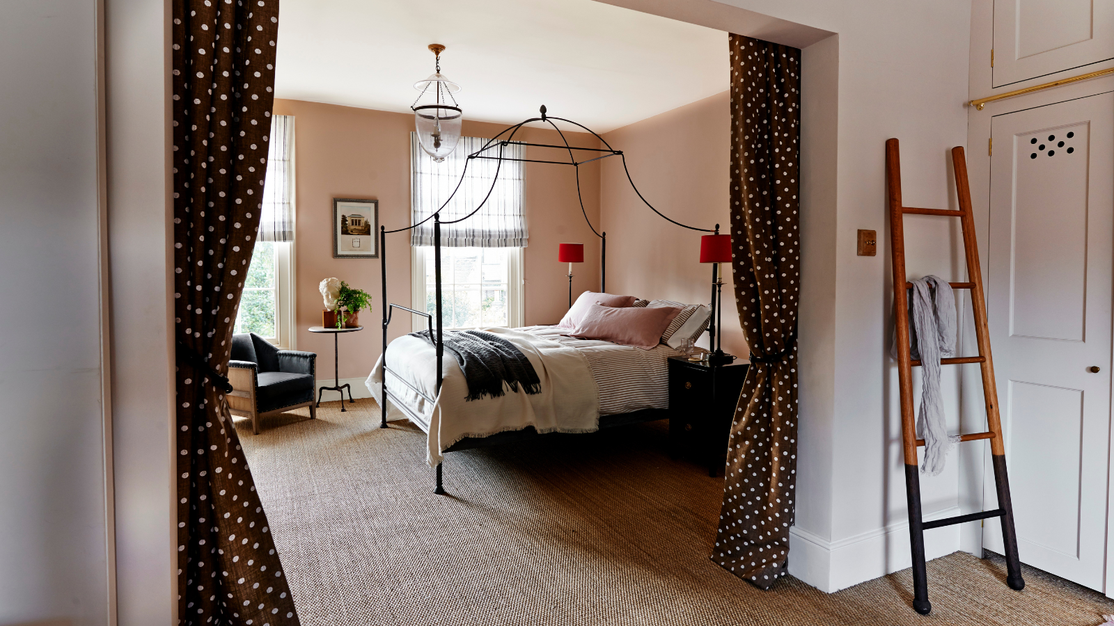 a bedroom with with polka dot drapes acting as a partition between the sleeping area and