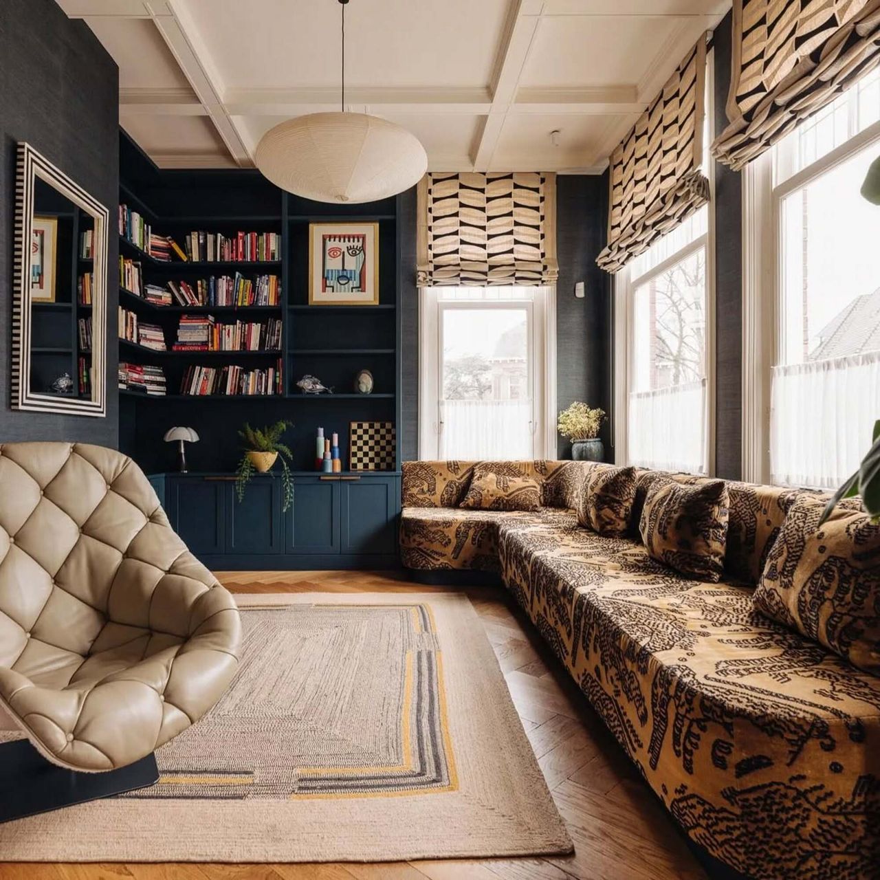 room with a blue bookshelf and a long couch with an orange and black print