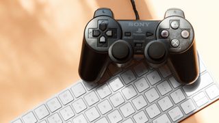 a mac keyboard with a playstation controller over it
