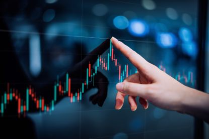 Close up of female hand touching stock market analysis digital display screen, analyzing investment and financial trading data in candlestick chart on a touch screen interface. 