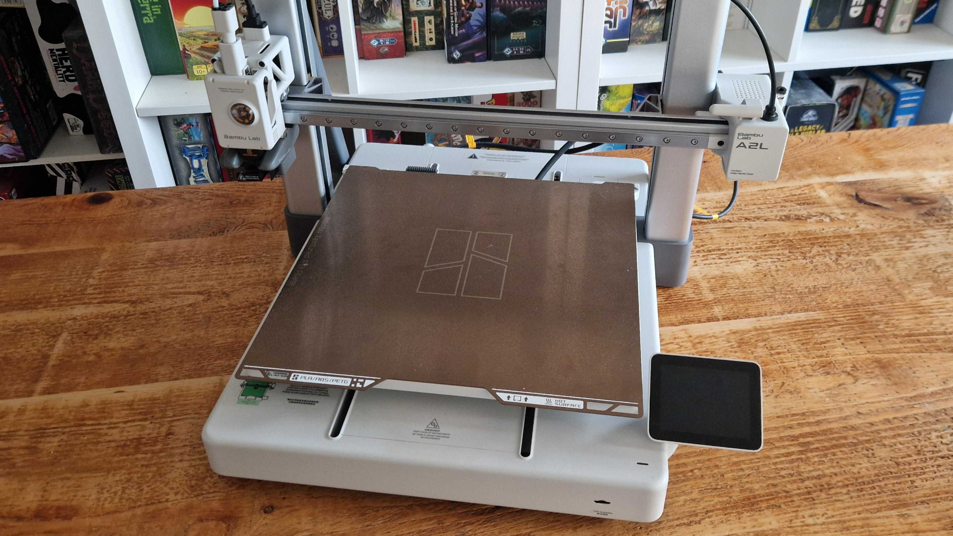 The Bambu Lab A2L 3D printer on a wooden table
