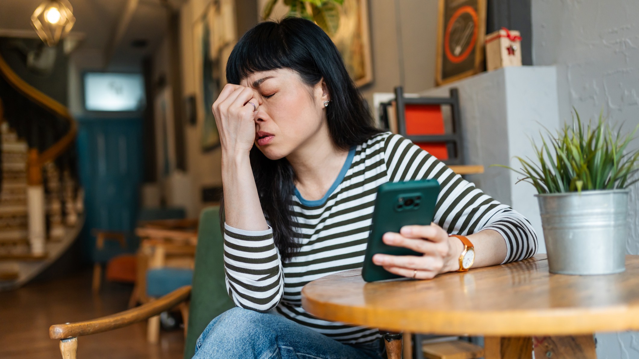 Woman holding smartphone looking frustrated