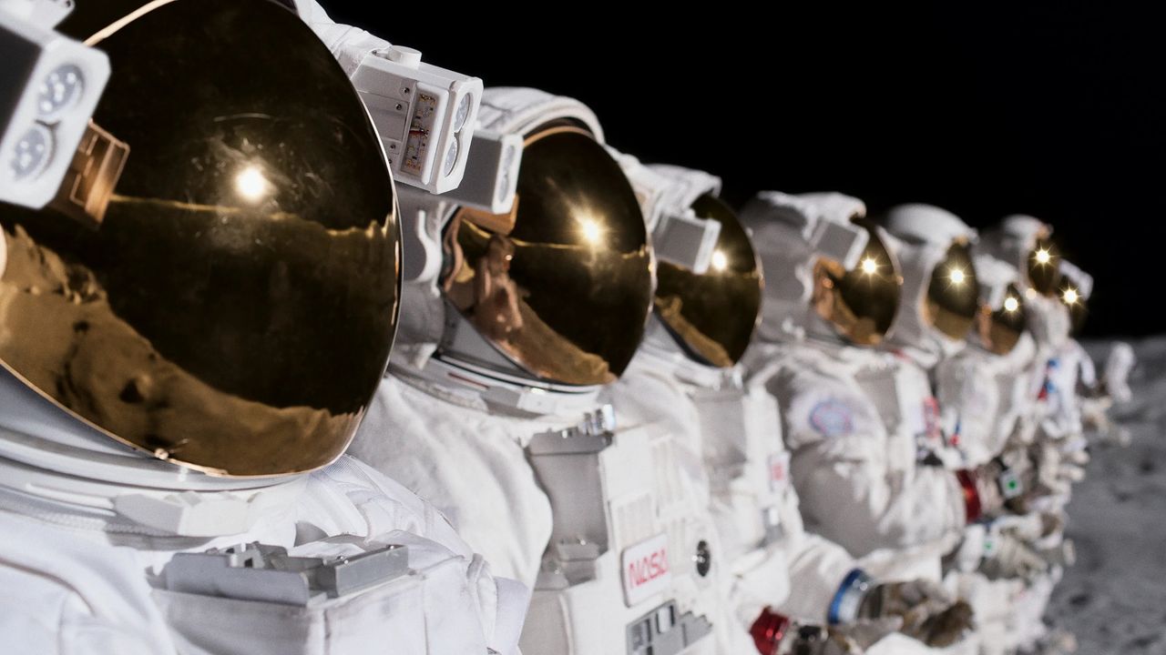 Screenshot from For All Mankind, showing a row of astronauts on the moon.