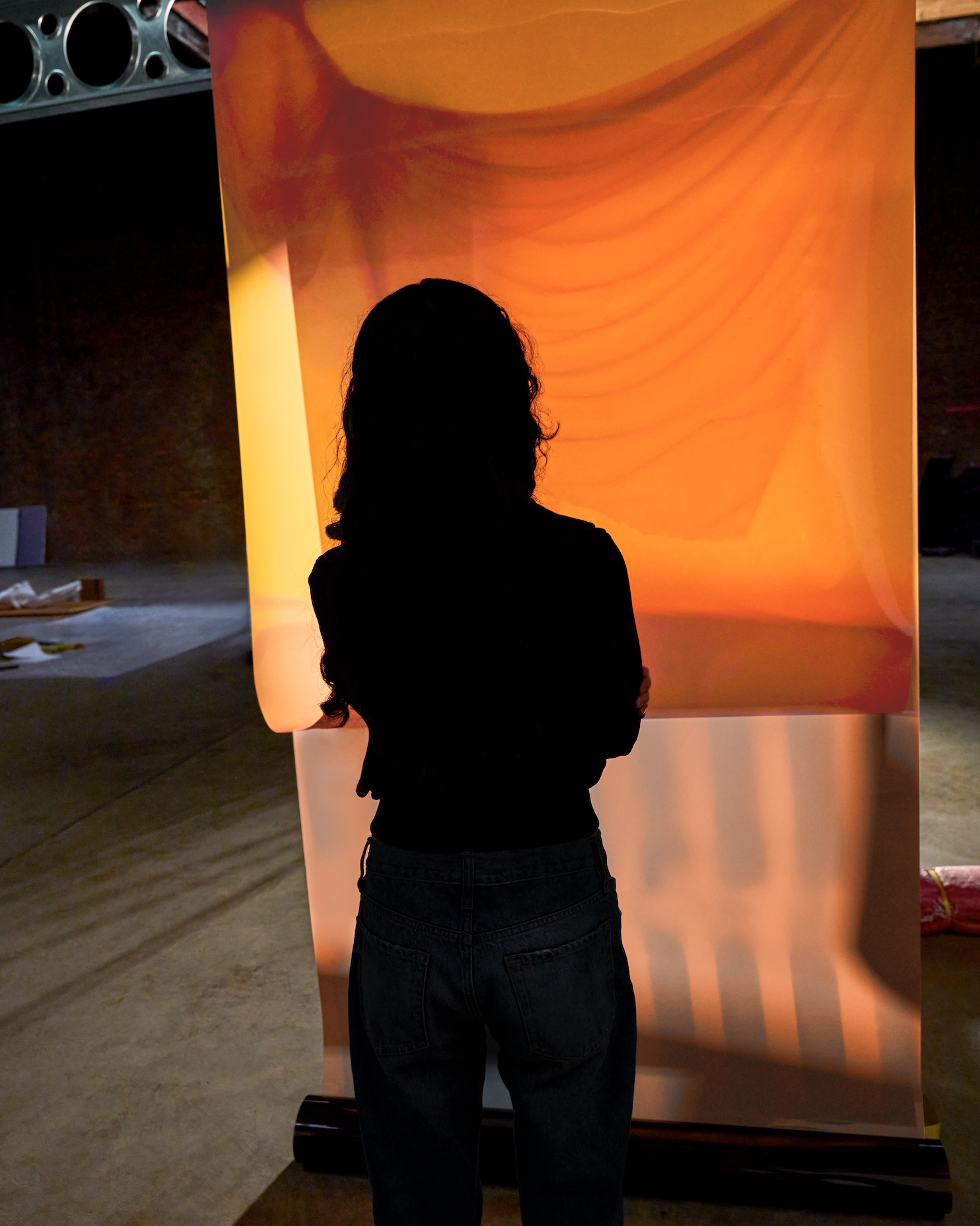 woman in front of orange curtain