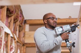 a man using a nail gun in a construction project