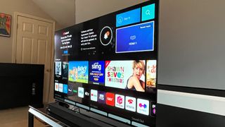 En LG A2 OLED TV står på en TV-bänk och visar en meny med filmer, serier och appar.
